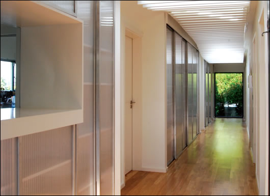 Two sets of Velux rooflights allow light tempered by timber louvers into the central corridor of the house
