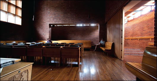 Inside the council chamber the lighting is dramatic, dim and directed to specific points