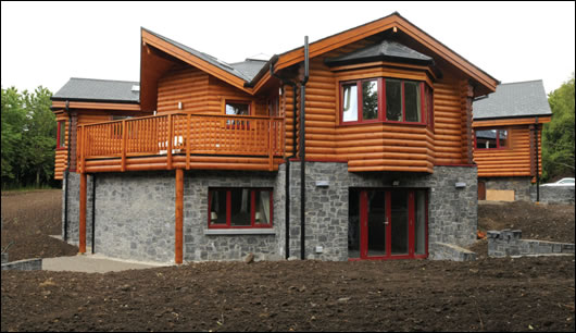 The extension features a timber-frame build-up with log cladding upstairs, while the lower floor here is comprised of reinforced concrete and cavity wall constructions