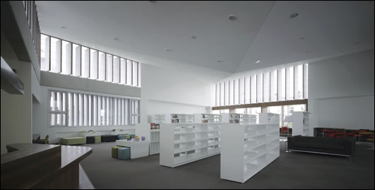 High-level windows allow daylight to penetrate deep into the reading room reflecting off the angled ceiling, while rotating vertical linen fins control the quality of light