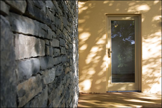 The contrasting finishes of the Aquapanel clad extension and stone outbuilding