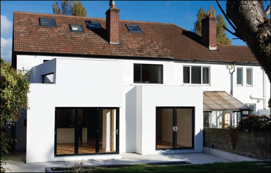 (above and below) The rear of the house before and after the renovation and extension