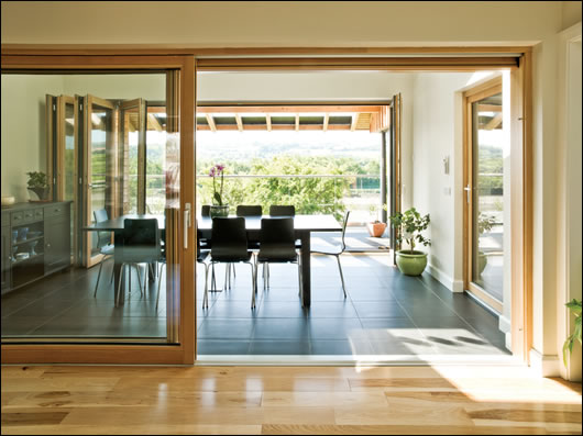 Glazed folding walls upstairs divide the main living space from the porch outside. 