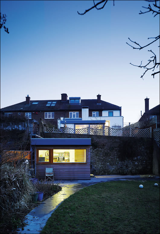 Set down near the banks of the River Dodder, the timber frame studio is sufficiently detached and secluded from the main house, located at the bottom of the garden. A sedum roof further helps it to blend in with its green surroundings