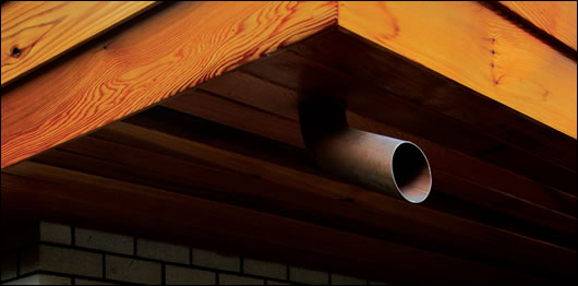 Non-traditional down-pipes adorn the exterior of the house. Instead of running to the ground, the pipes extend only a short distance Non-traditional down-pipes adorn the exterior of the house. Instead of running to the ground, the pipes extend only a short distance